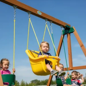 A secure yellow toddler bucket swing seat hanging from a swing set, a safe and comfortable swing set add on for very young children.