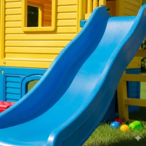 A close-up shot of the blue plastic slide attached to the side of a children's playhouse with slide and swing.


